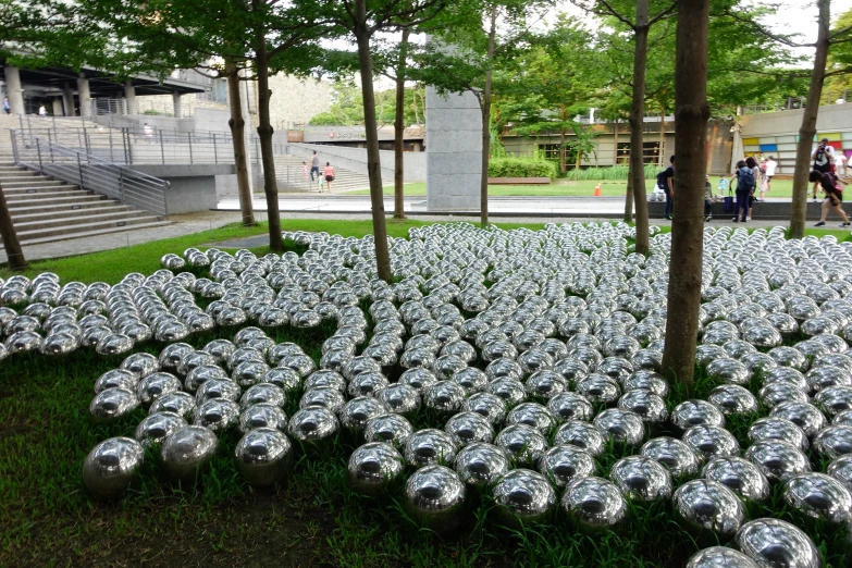 a field of large circular metal bowls in a park