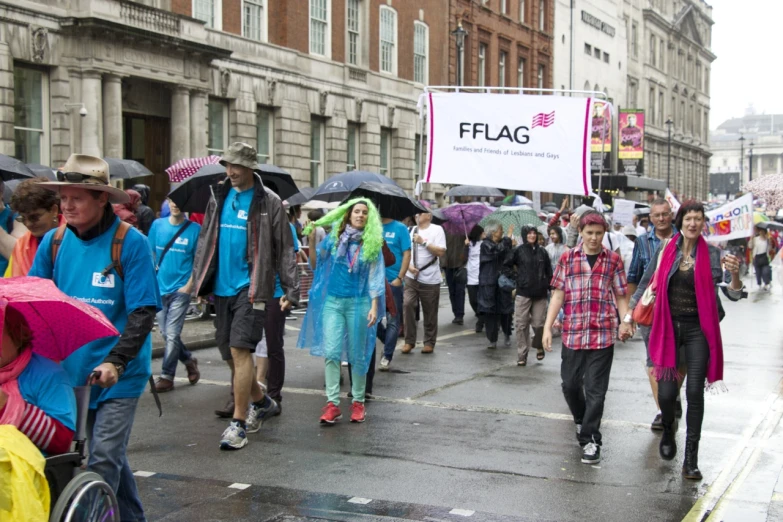 many people marching down the road with umbrellas