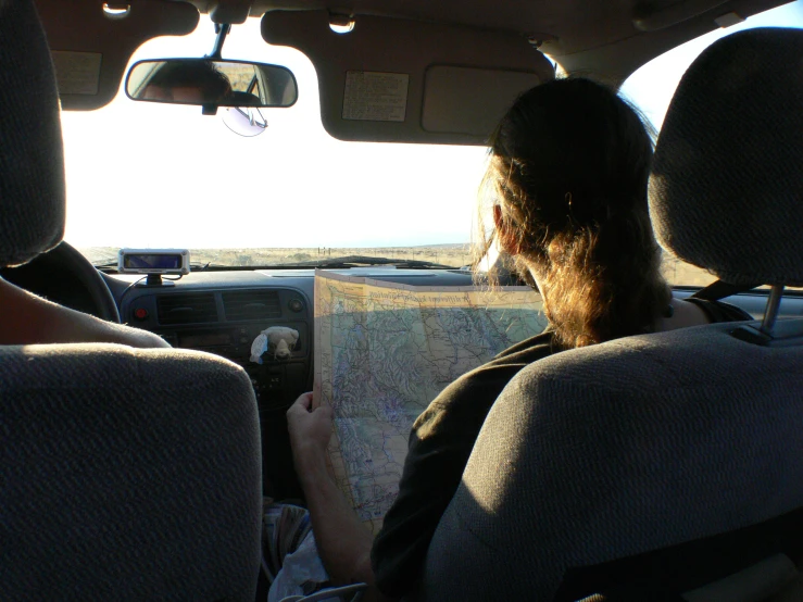 a young woman in the backseat looking at a book