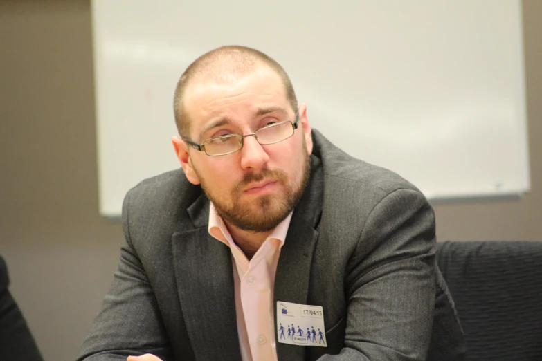 a man in business attire sits at a desk