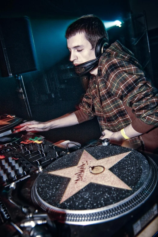 a man wearing headphones sits at a table with a record player