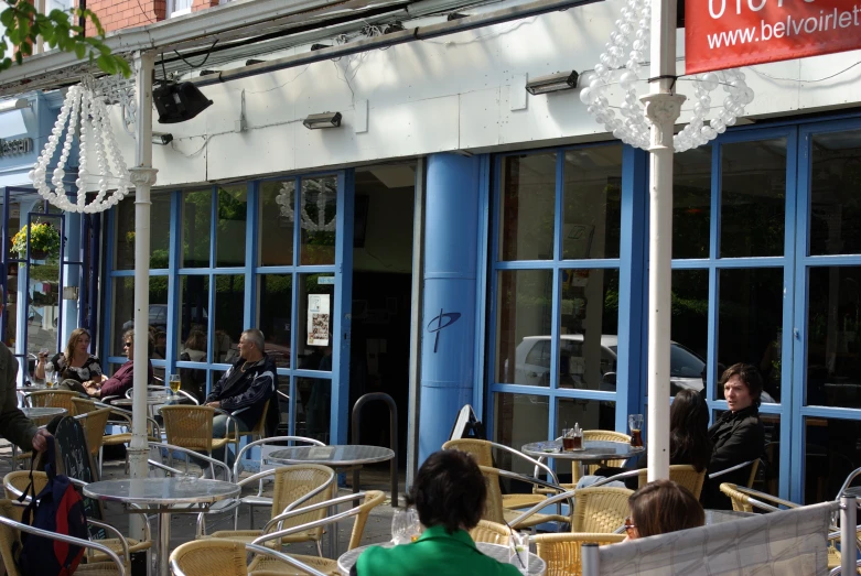 several people sitting outside an outdoor restaurant