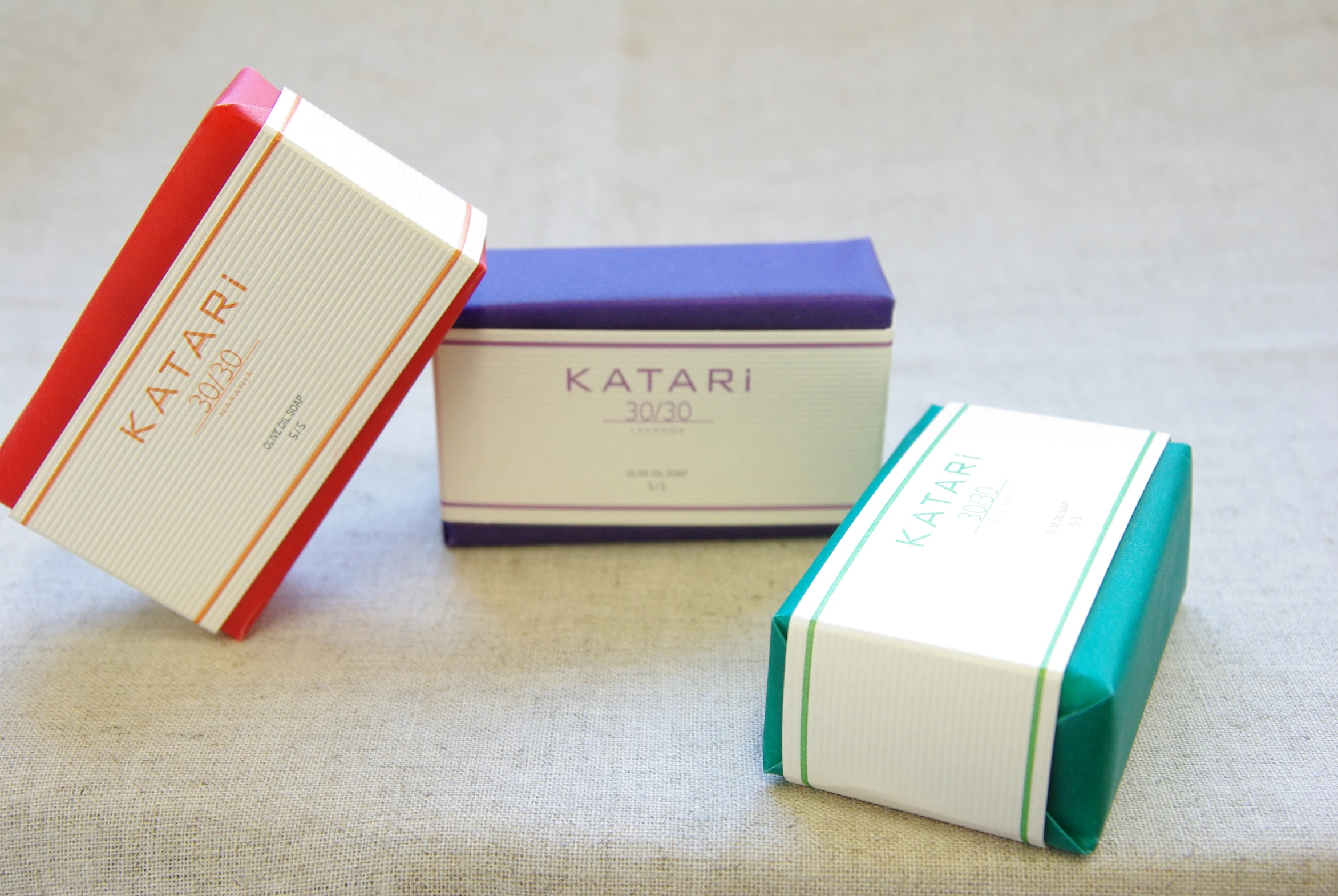 four colorful boxes of soap sitting on a white surface