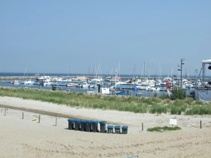 a harbor filled with boats surrounded by grass and sandy sand