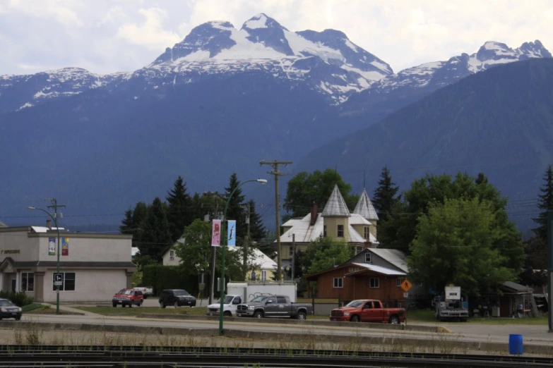 some cars parked in front of snow capped mountains