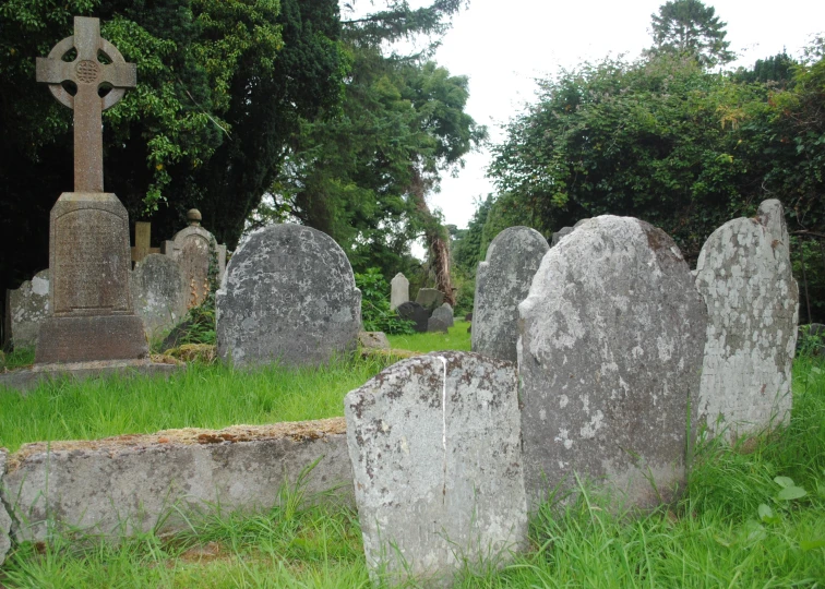 a graveyard has a cross and a stone fence