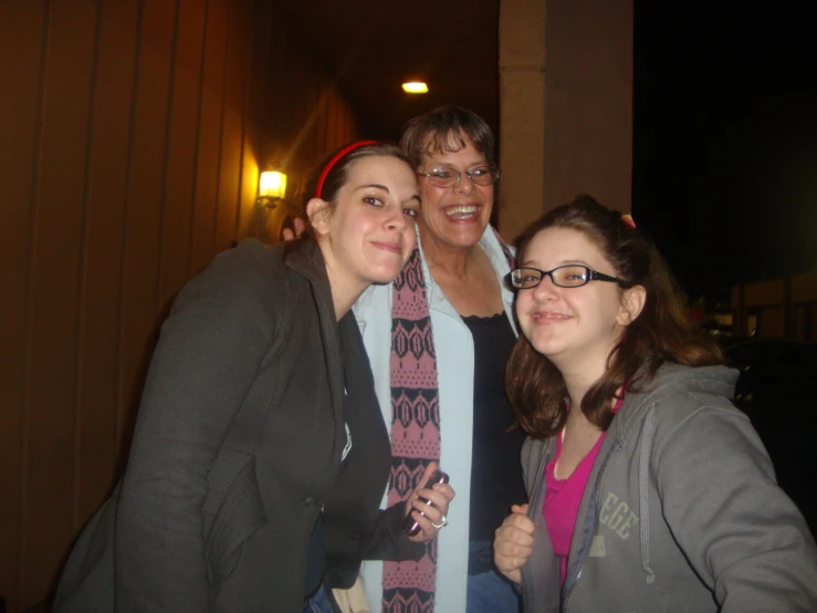 three young women and one old woman are posing for a picture