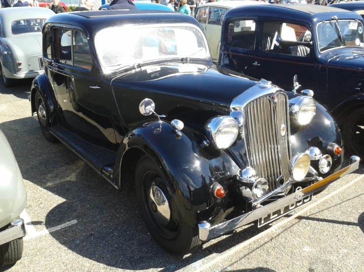 some old timey cars are parked in a parking lot