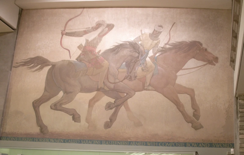 a wall mounted painting of a group of native cowboys on horses