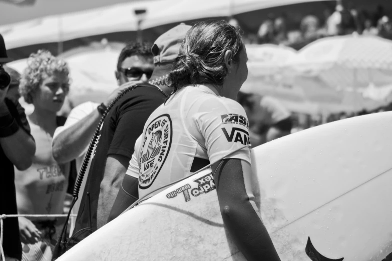 a person with a surfboard standing in front of people