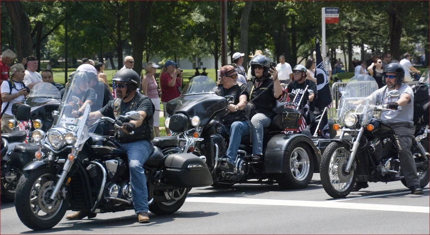 a group of people on motorcycles ride down the street