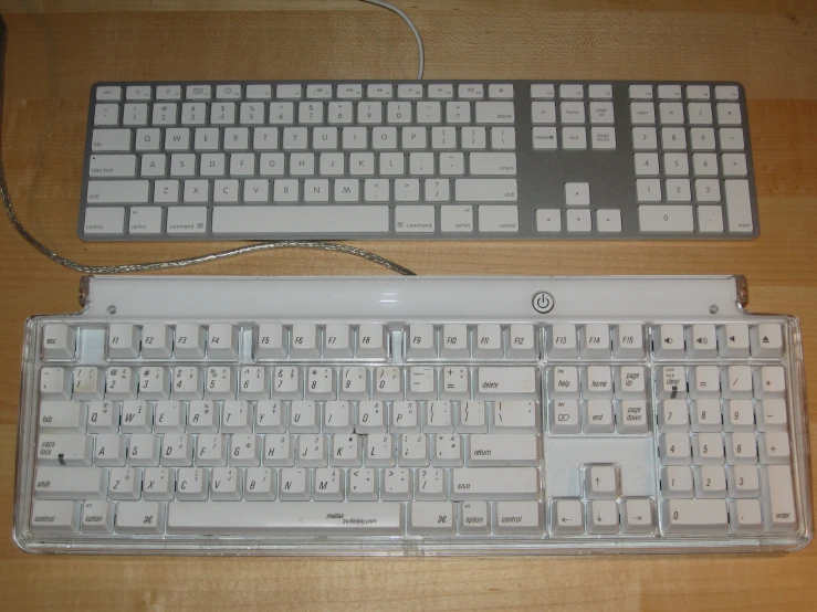 a white computer keyboard on a wooden surface