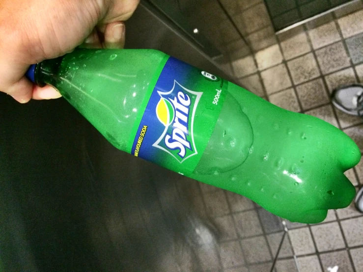 someone holding a bottle of sprite soda