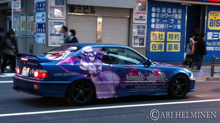 a colorfully decorated car on a street near a building