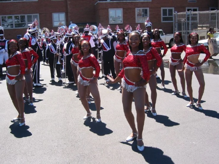 several women in short skirts and red shirts dancing on street