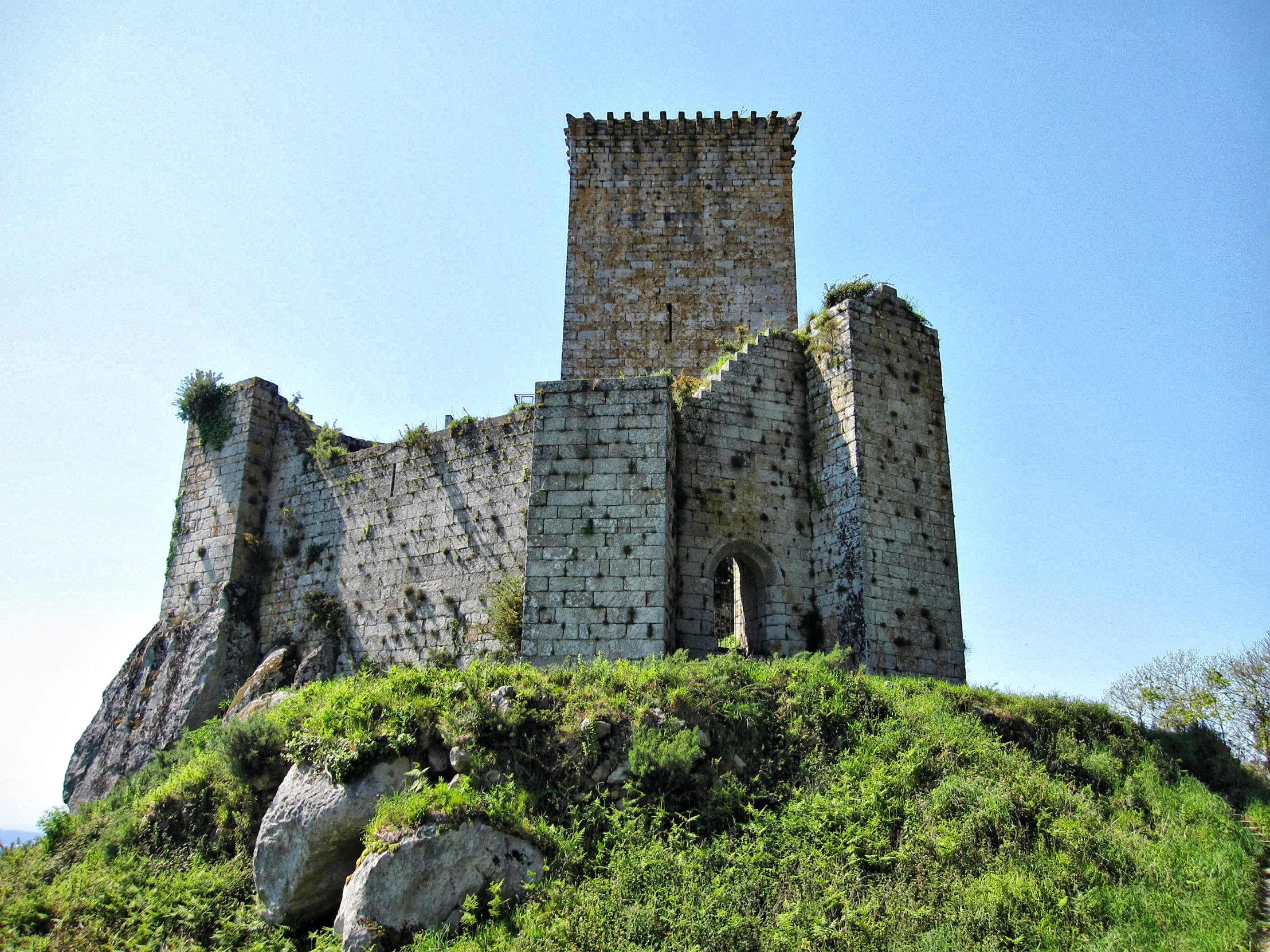 a castle on top of a lush green hill