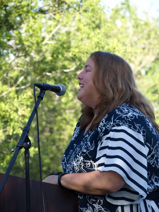 a woman holding a microphone up to her ear