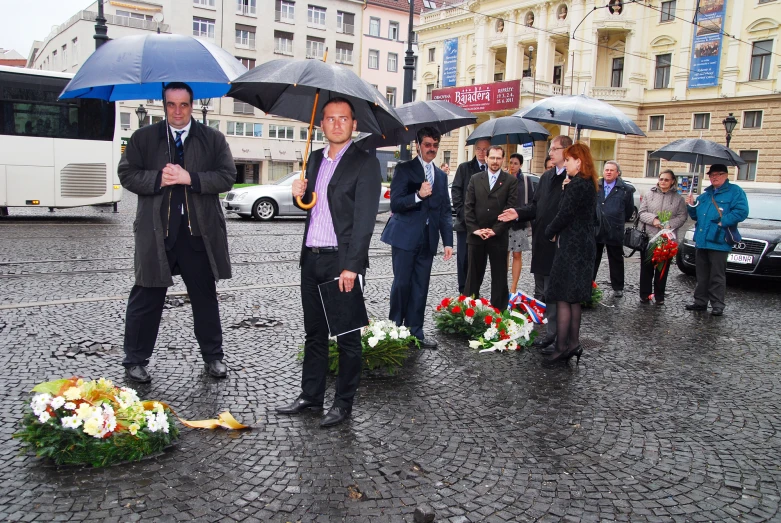 a group of people holding umbrellas standing in the rain