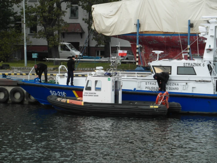 several men standing on the edge of a boat in a body of water