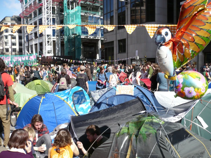 many people are gathered in the street with their tents