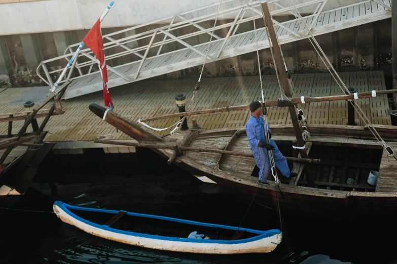 an image of people walking past the sailboats