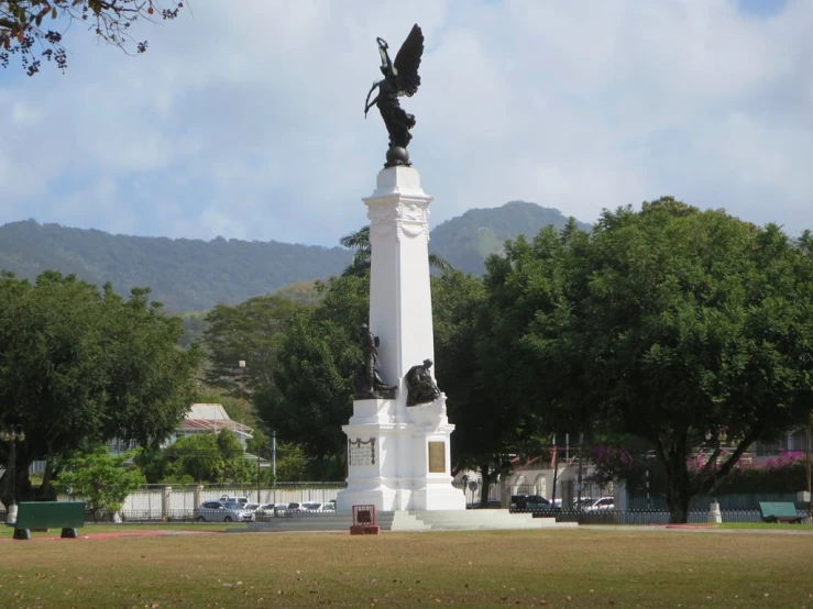 a statue with wings in the middle of a park
