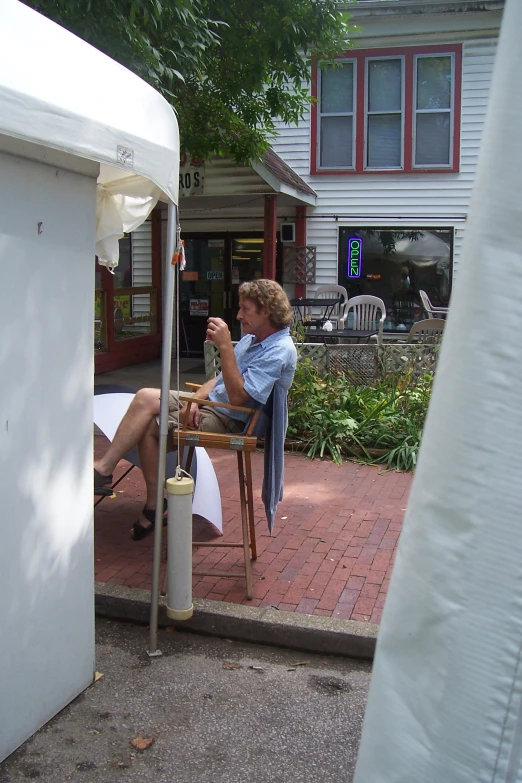 a woman sitting on top of a chair next to a white water hydrant