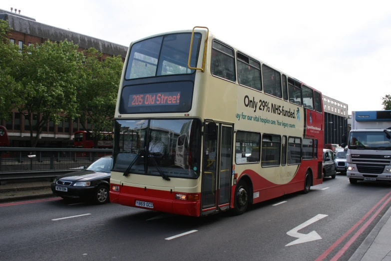 a double decker bus driving down the street next to other traffic