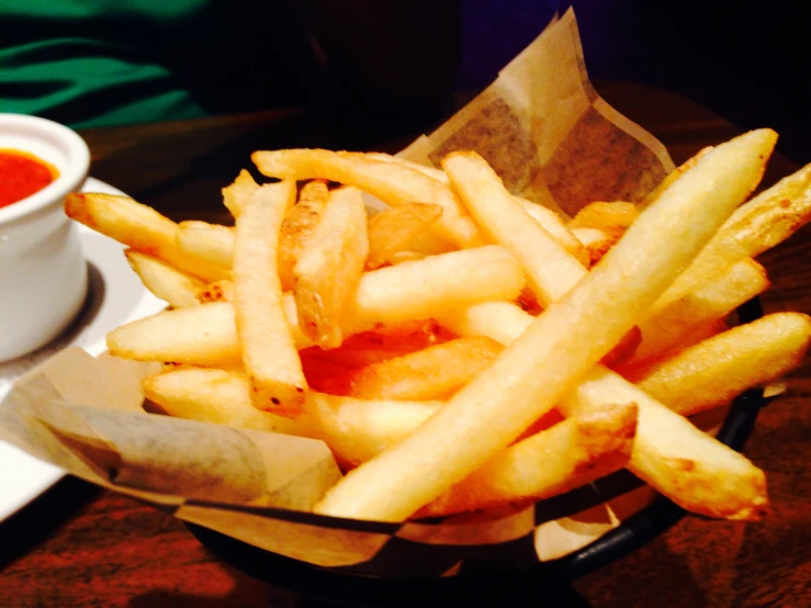 some french fries sit in a bowl on a table