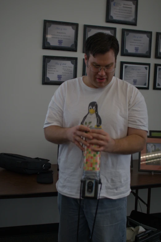 a man is holding a stuffed toy penguin