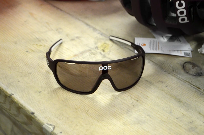 a pair of polarized sunglasses sits on a wood table