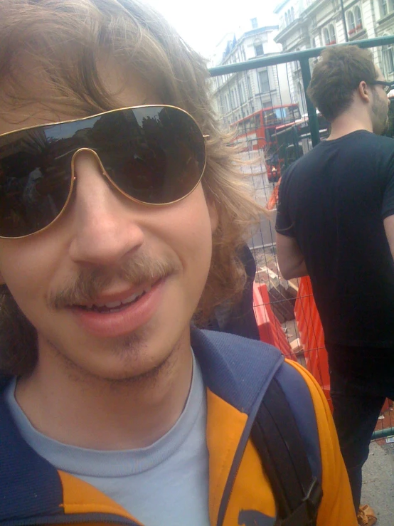 the man has a mustache wearing sunglasses