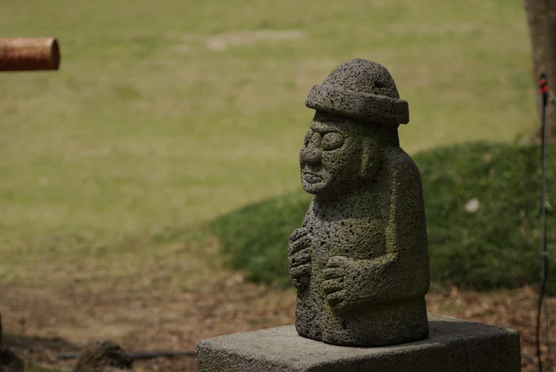 statue sitting on top of cement block near grass