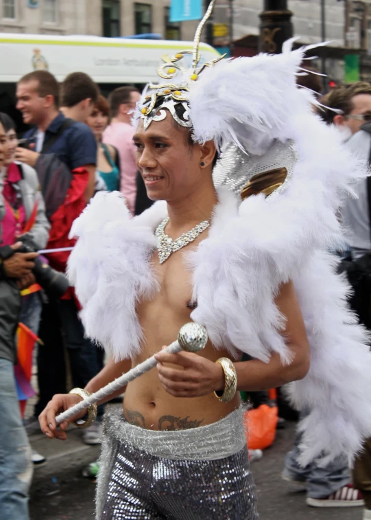 a man with  in the street wearing feathery outfits