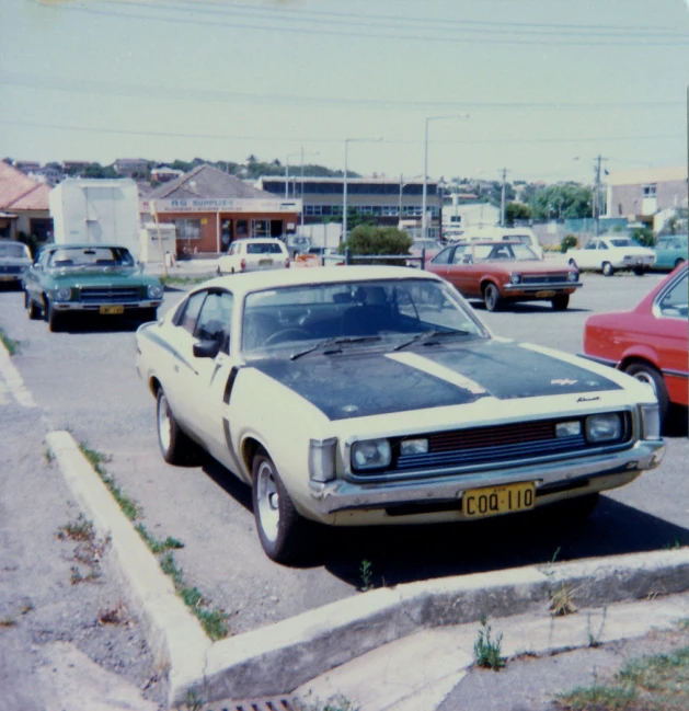 the old muscle car is in the parking lot