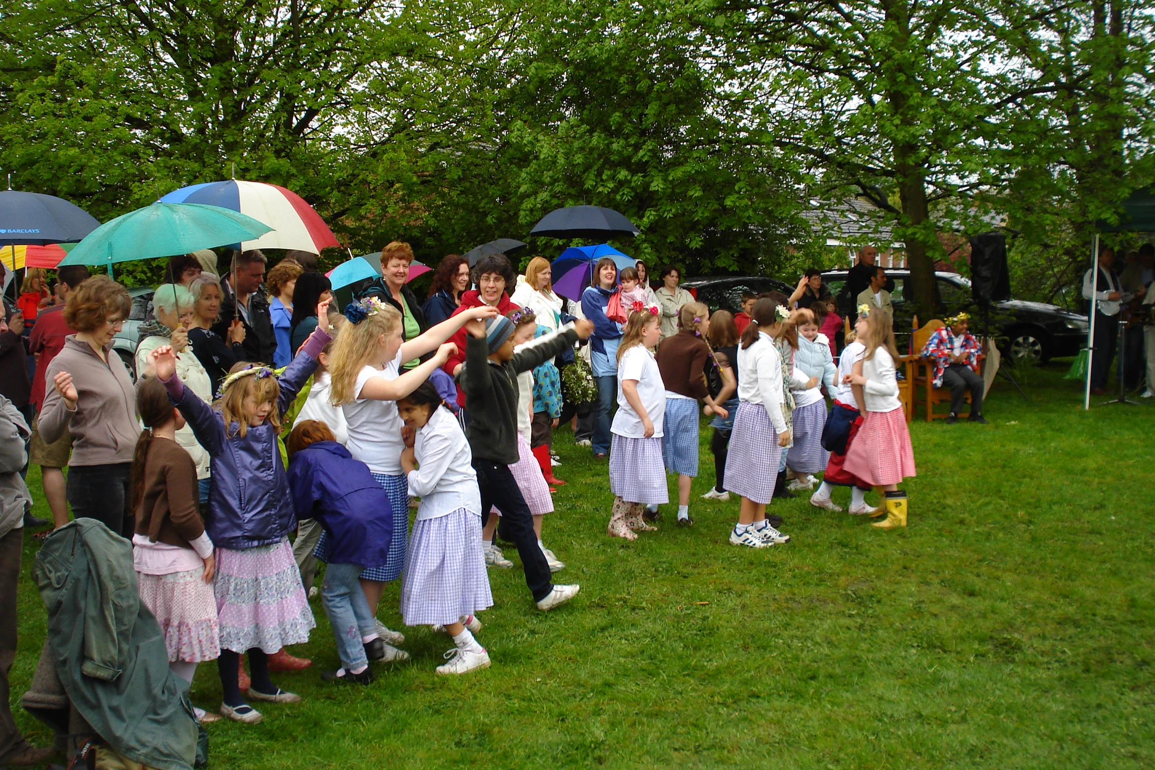 there are many people standing on the grass with umbrellas