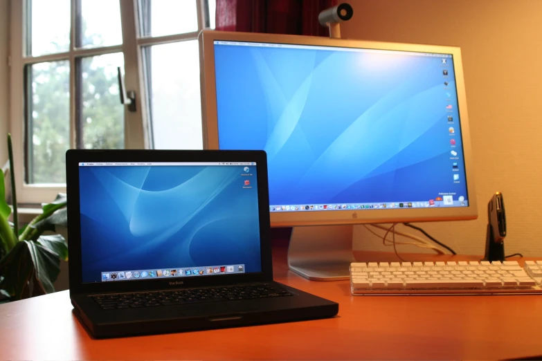 an apple laptop and desktop computer with the same screen open