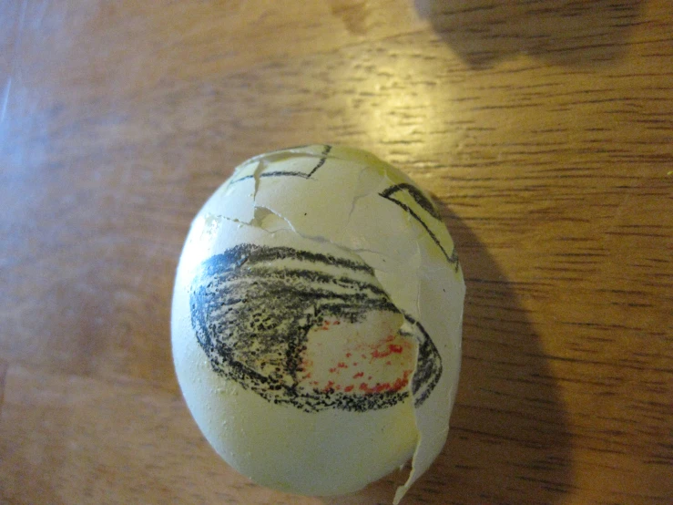 the decorated egg is on the wood table
