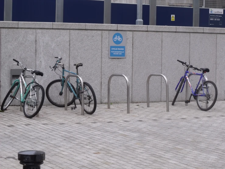 three bikes are locked together by a parking meter