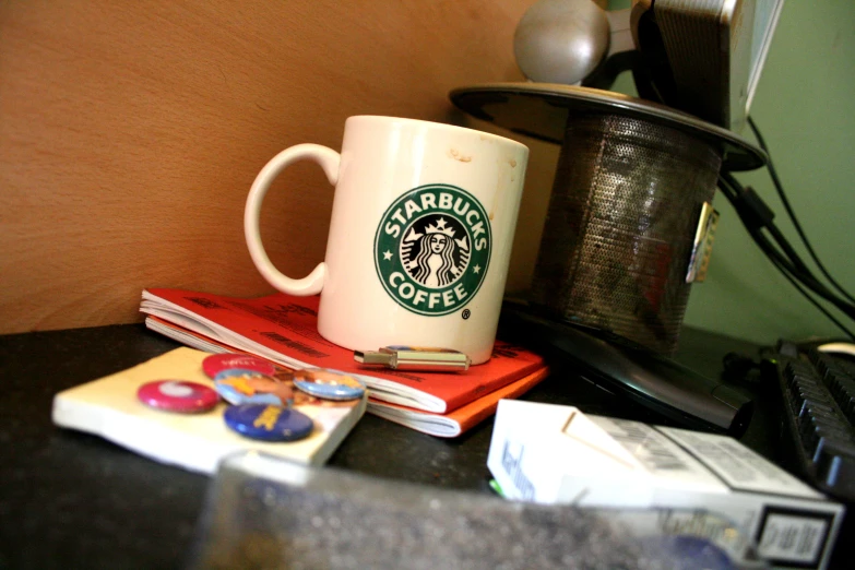 starbucks mug sitting on top of a stack of papers