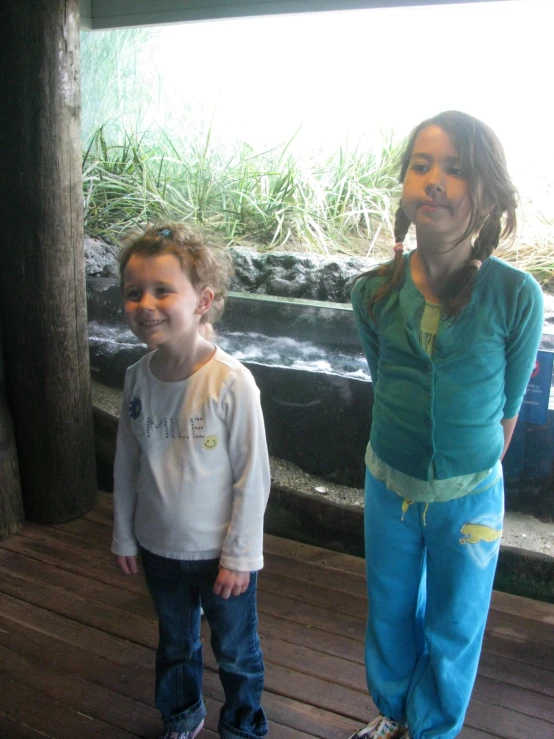 a mother and child posing for a picture by water