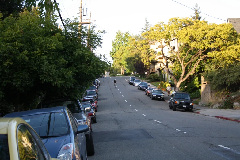 a street with many cars parked on both sides of it