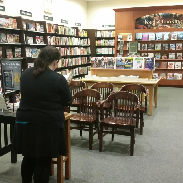 people standing around reading books in the liry