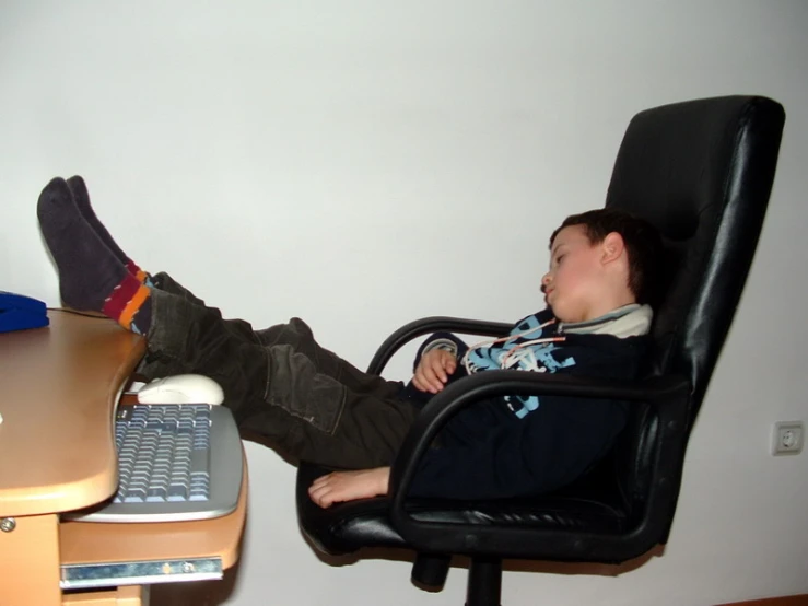 a  is resting his feet on the desk chair