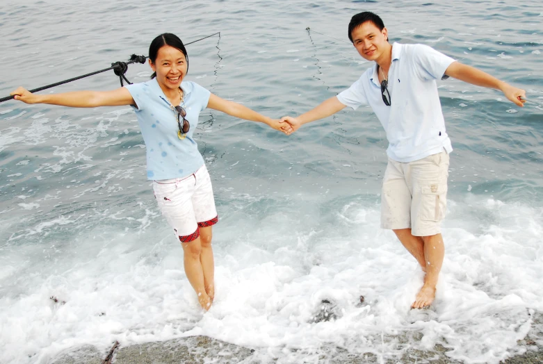 two people are in the water holding hands