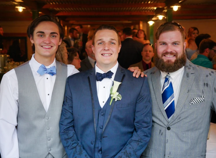 three men in suits and ties posing for the camera