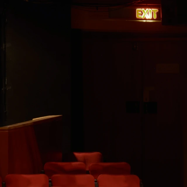 a red theater seat is lit up in the dark