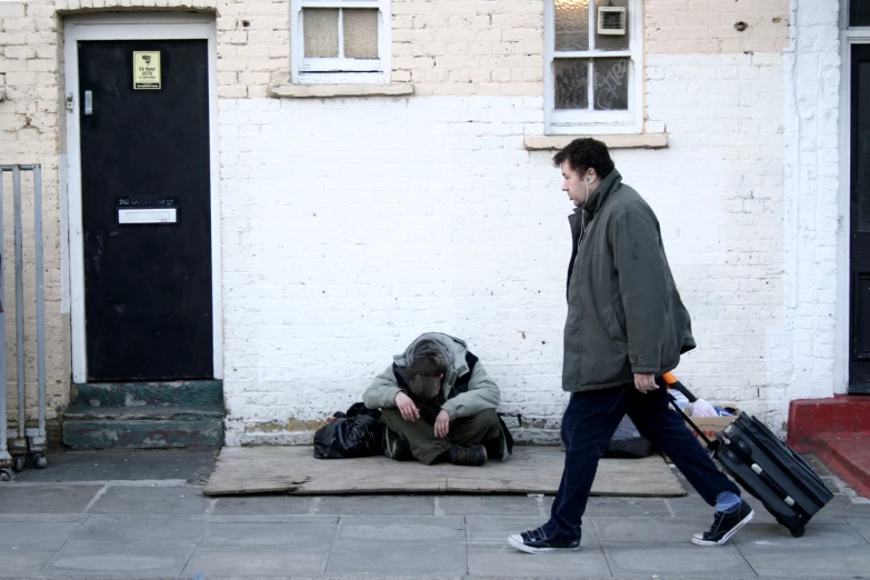 a man walking down the street with his luggage