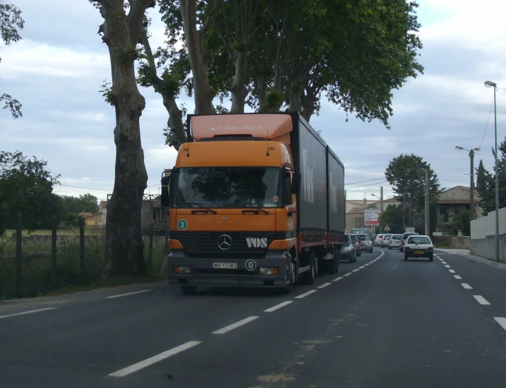 an orange truck is driving down the street