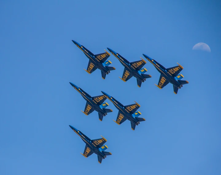 four jets flying in formation on a sunny day